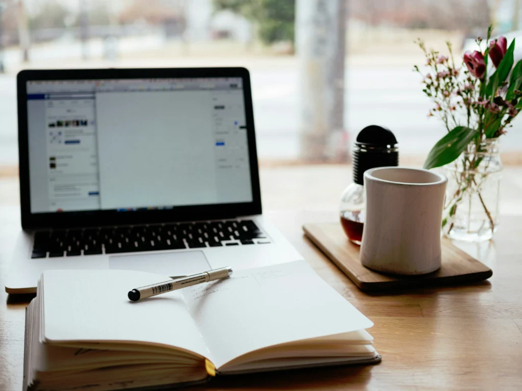 Desk flat lay with laptop, planner, and website content planning tools