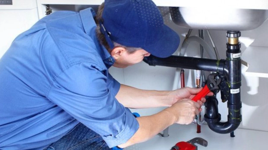 Image of plumber working under sink